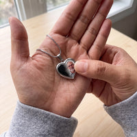 Thumbnail for Thumb warming the silver heart pendant: the hidden photo appears under the thumb while the rest stays black | SKU: TPH-CHTN-SILVER-SMALL