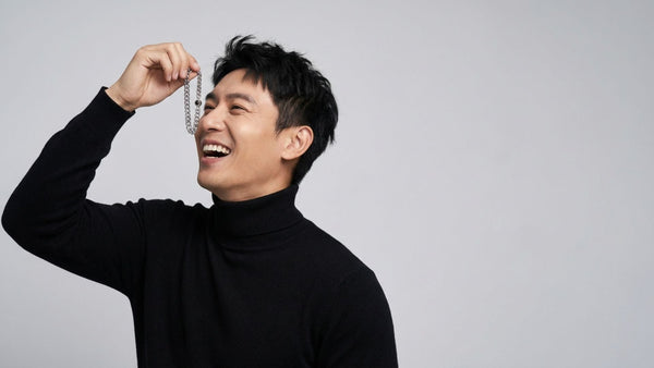Man joyfully holding a picture bracelet for him, showcasing a unique gift option.