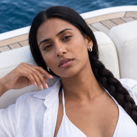 Thumbnail for Woman on a yacht wearing the silver huggie hoop earrings | SKU: 22023999-rhodium