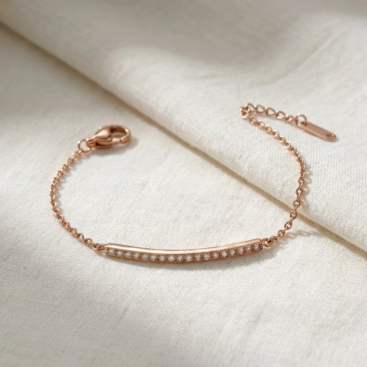 Crystal Bar Bracelet en acier inoxydable 304L or rose, barre sertie de cristaux, pose a plat sur du lin